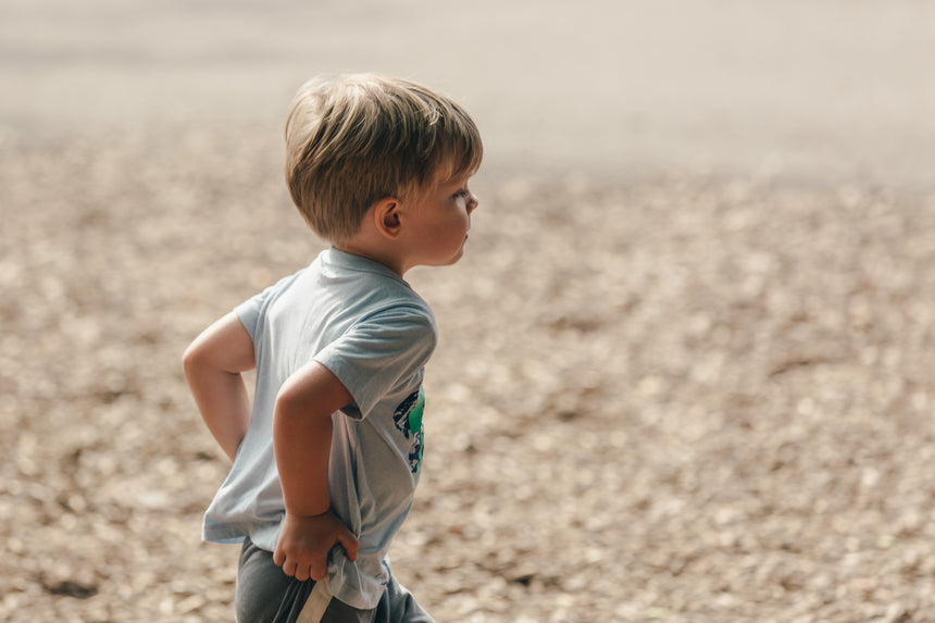 young blonde boy playing outside